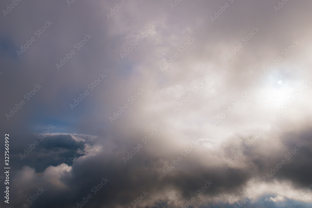 The high contrast view of a dramatic moody sky with several layers of clouds and the sunlight The high contrast view of a dramatic moody sky with several layers of clouds and the sunlight