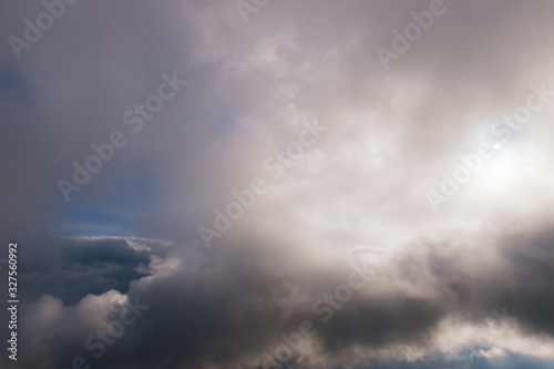 The high contrast view of a dramatic moody sky with several layers of clouds and the sunlight