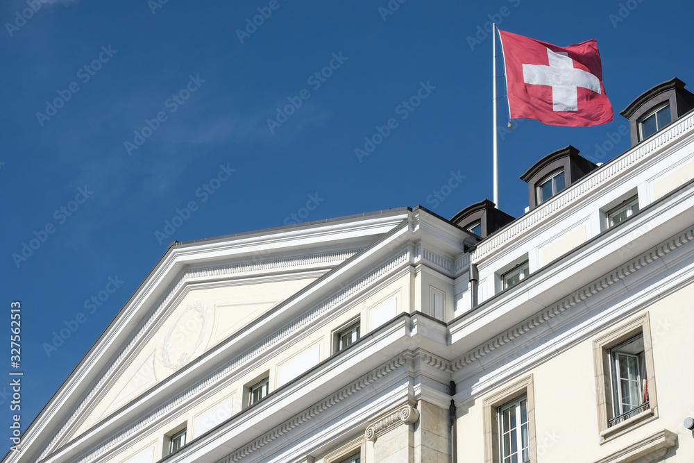 Swiss flag on the roof of a luxury hotel in Geneva Switzerland Swiss flag on the roof of a luxury hotel in Geneva Switzerland