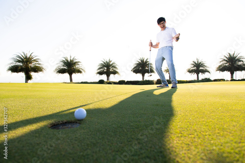 Professinal golf player on golf course. Pro golfer taking a shot