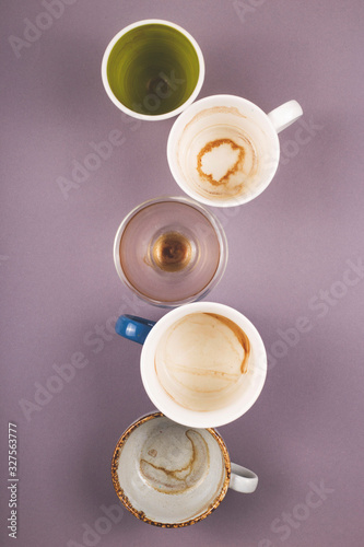Several empty cups of coffee viewed from above on gray table. Top view layout.