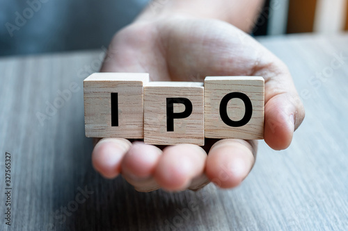 Businessman hand holding IPO (Initial Public Offering) word with wooden cube block, shares of a private corporation to the public in a new stock issuance. Stock, Fund, Investors and Investment concept photo