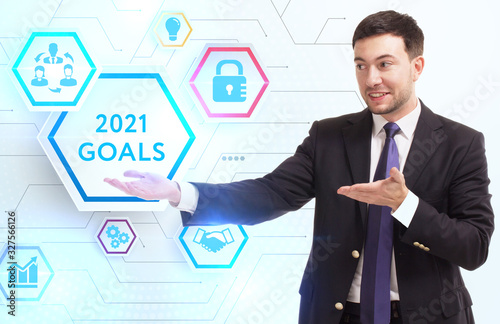 Business, Technology, Internet and network concept. Young businessman working on a virtual screen of the future and sees the inscription: 2021 goals