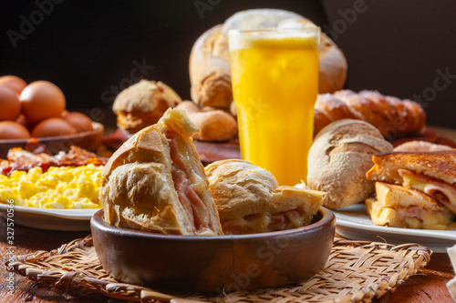 café da manhã com sanduiches, ovos, bacon e suco de laranja photo