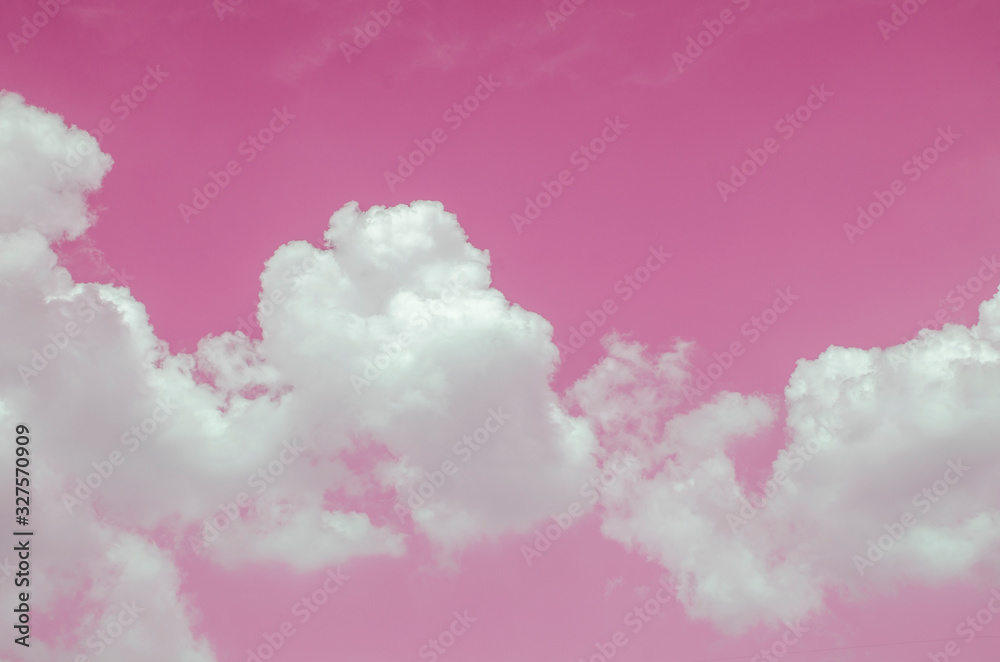 White clouds against the pink sky against a blurred patterned background White clouds against the pink sky against a blurred patterned background
