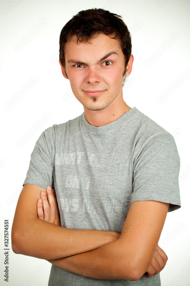 Portrait of a Caucasian young positive guy in a gray shirt and jeans posing on a gray background. Concept of a successful young student or novice employee. Advertising space Portrait of a Caucasian young positive guy in a gray shirt and jeans posing on a gray background. Concept of a successful young student or novice employee. Advertising space