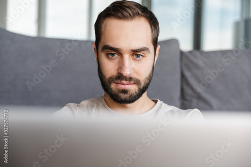 Concentrated young man using laptop computer.