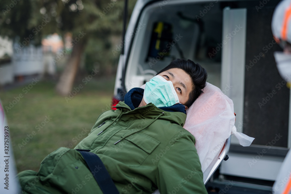 Man on stretcher by ambulance outdoors, coronavirus concept. Man on stretcher by ambulance outdoors, coronavirus concept.