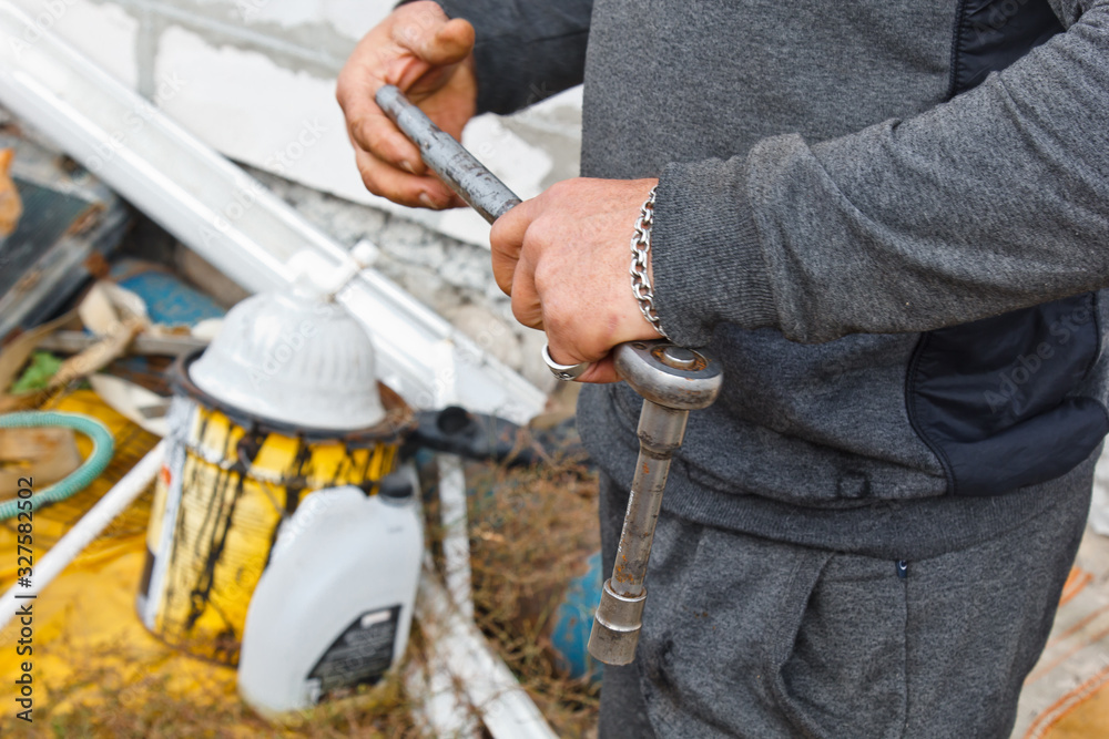 Auto mechanic man with electric screwdriver changing tire outside. Car service. Hands replace tires on wheels. Tire installation concept. Auto mechanic man with electric screwdriver changing tire outside. Car service. Hands replace tires on wheels. Tire installation concept.