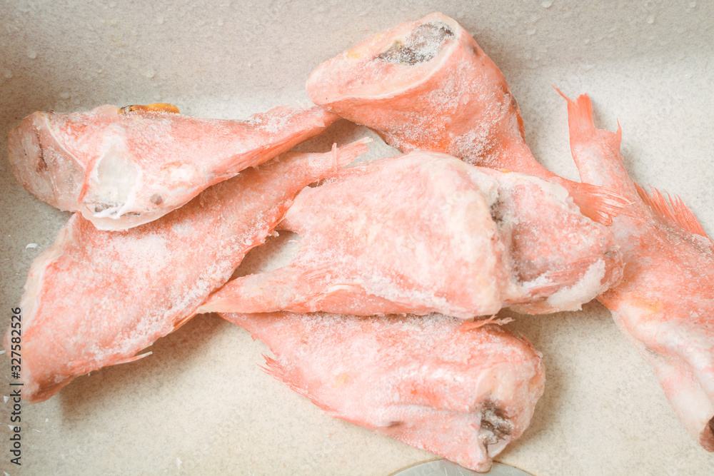 Frozen sea bass in kitchen sink lies to defrost. Frozen sea bass in kitchen sink lies to defrost.