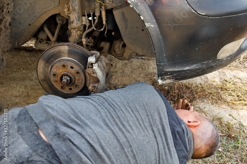 Service process. A man holds a tire in the garage. Replacing winter and summer tires. Seasonal tire replacement concept.