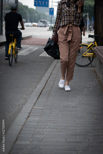 Woman dressed in casual clothing walking in the streets of Beijing in China