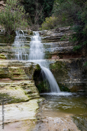 Beautiful waterfall splashing in the canyon creating a small lake