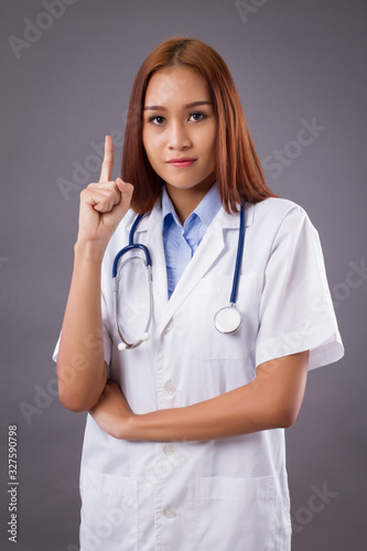 portrait of asian woman doctor isolated  confident and friendly female doctor pointing up one finger