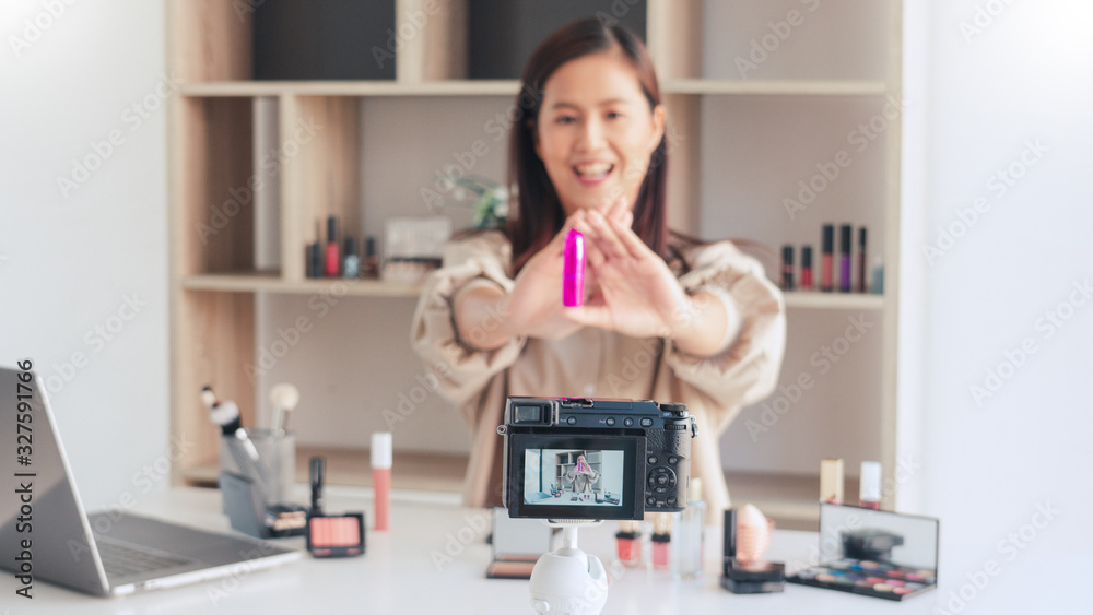 beautiful asian woman professional beauty vlog or blogger present cosmetics and applying make-up in front camera for recording video.