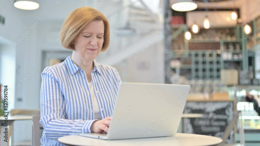 Thumbs up by Creative Old Woman using Laptop in Cafe Thumbs up by Creative Old Woman using Laptop in Cafe