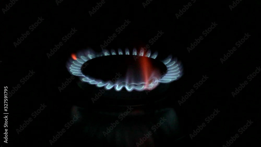 Kitchen burner turning on. Stove top burner igniting into a blue cooking flame. Black background. Natural gas inflammation, close up. Footage 1080p. Kitchen burner turning on. Stove top burner igniting into a blue cooking flame. Black background. Natural gas inflammation, close up. Footage 1080p.