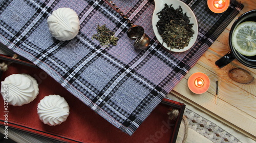 top view of a composition for tea drinking with sweets on a checkered tablecloth