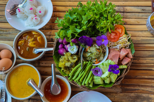 Thai foood Rice noodles in crab curry sauce with vegetables on wooden table..S photo