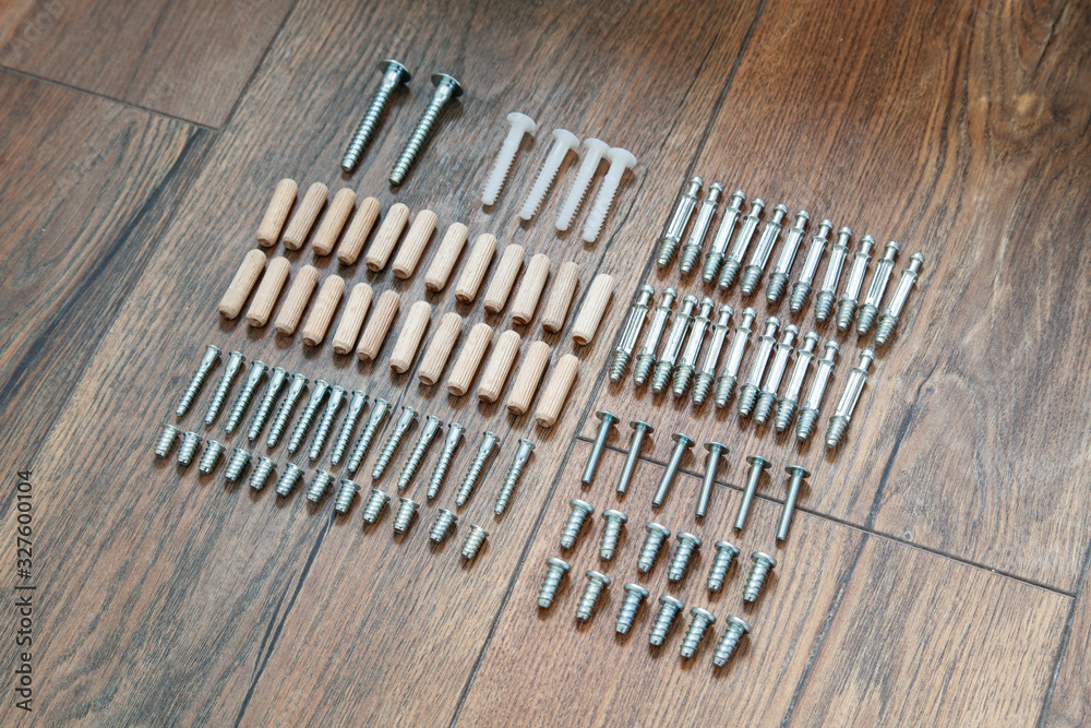 Top view arrangement group of parts (dowel, bolt, screw) for furniture assembly on wooden floor. Tools for assembling furniture. DIY concept. Top view arrangement group of parts (dowel, bolt, screw) for furniture assembly on wooden floor. Tools for assembling furniture. DIY concept.