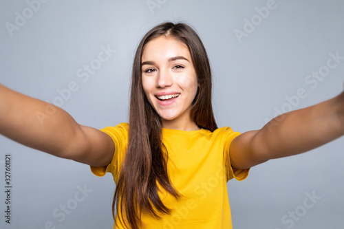 Pretty young woman making selfie on white background © dianagrytsku
