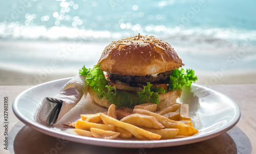 Burger on a plate on a table in the street at a resort.