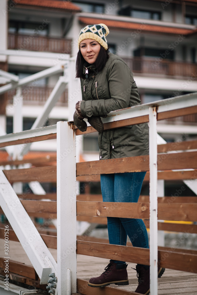 Woman with winter clothes standing on bridge Woman with winter clothes standing on bridge