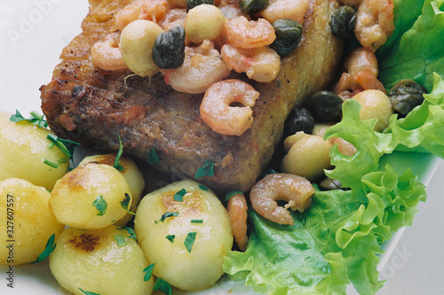 peixe frito com molho de camarões e batatas photo