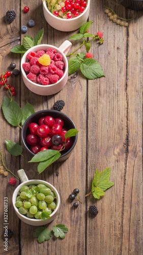 Fototapeta Naklejka Na Ścianę i Meble -  different berries on old wooden background