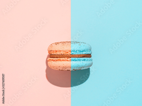 Creative layout with macaron. Trendy light. Two colors macaron or macaroon on duotone coral pink and blue background. Top view or flat lay. Hard light