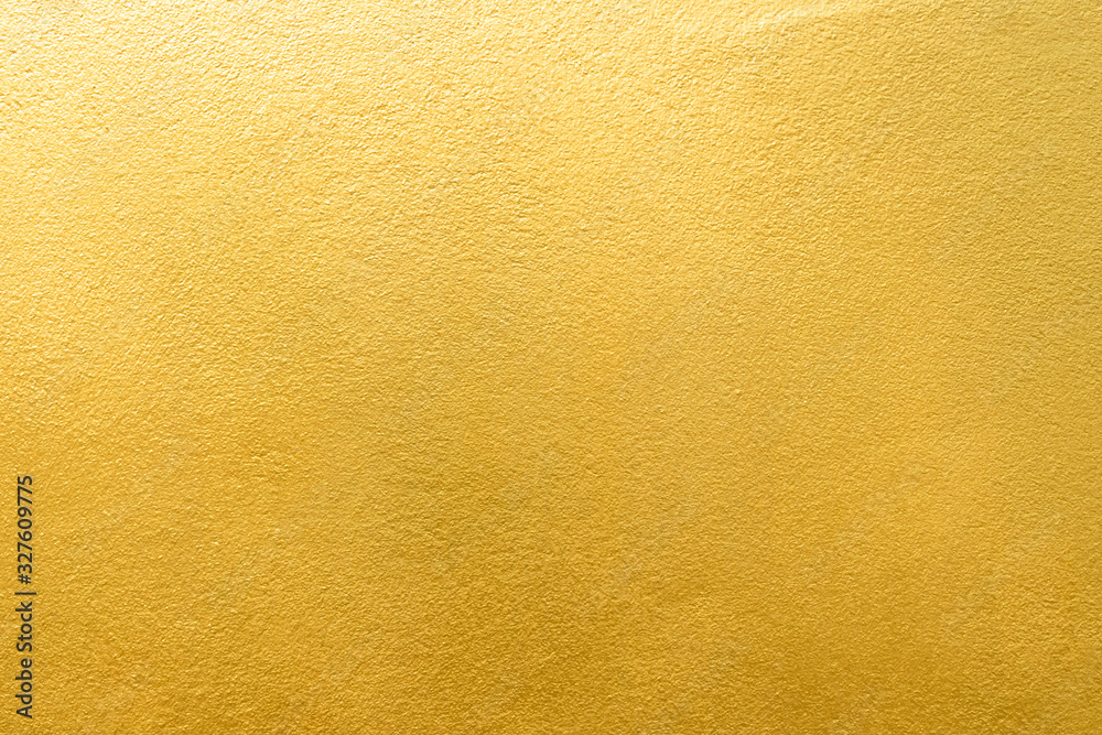 Gold wall texture background. Yellow shiny gold foil paint on wall surface with light reflection - obrazy, fototapety, plakaty 