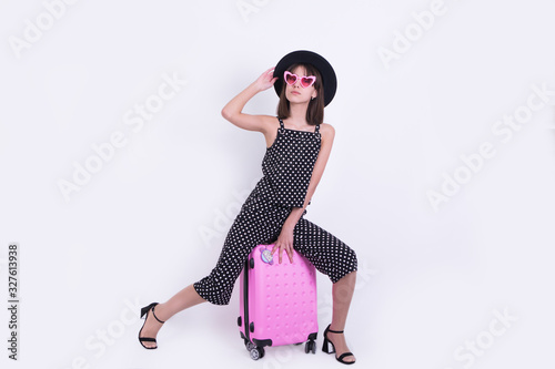 girl in a farm hat with a pink suitcase