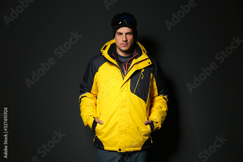 Man wearing stylish winter sport clothes on black background