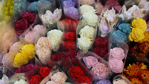Colorful artificial roses for sale, wrapped in transparent wrapper. © CloudyTheater