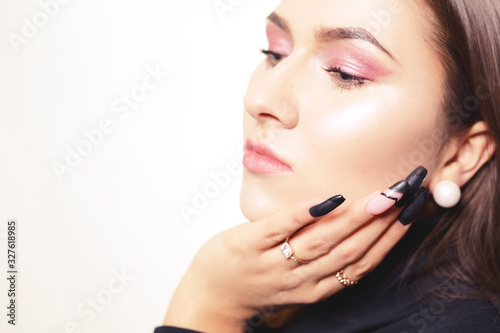 Portrait of a girl with long nails, close-up of a girl with pink shadows, professional eyebrows. Beautiful eyebrows.