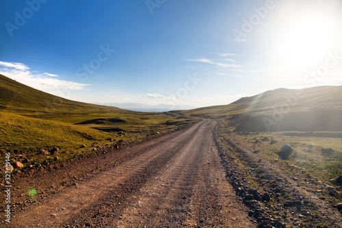 Unpaved road and Tian Shan mountains in Kyrgyzstan photo