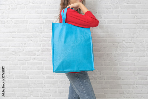 Womenl is holding bag canvas fabric for mockup blank template. photo