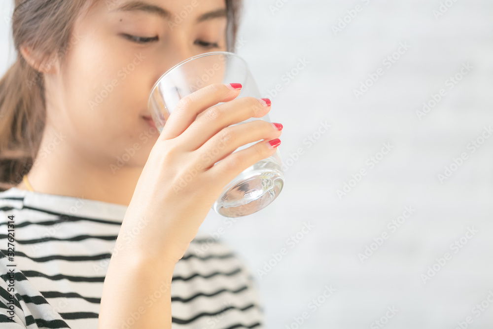 Beautiful asian woman drinking water. Closeup and focus on her arm. Beautiful asian woman drinking water. Closeup and focus on her arm.