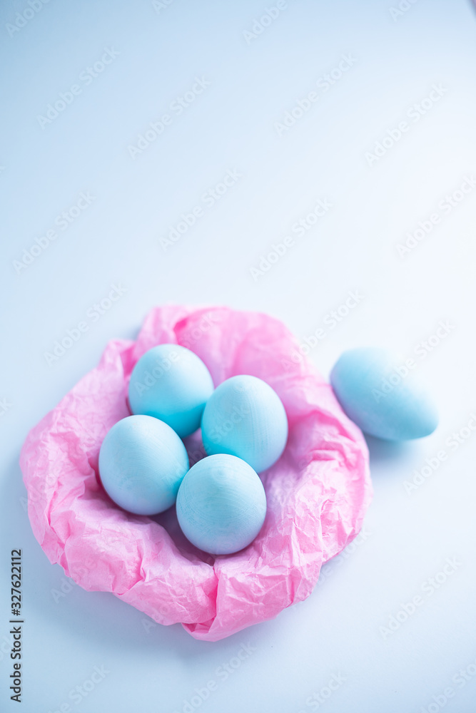 Blue Easter eggs in a pink paper nest on a blue background. Top view free space for copying. Easter concepts Blue Easter eggs in a pink paper nest on a blue background. Top view free space for copying. Easter concepts