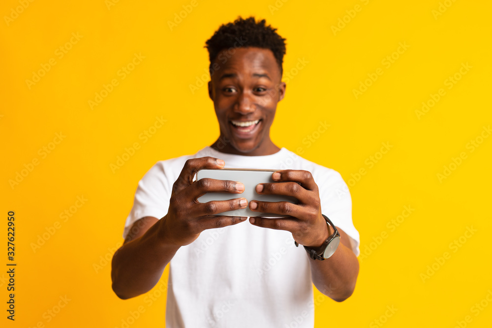 Portrait of excited young african man playing games