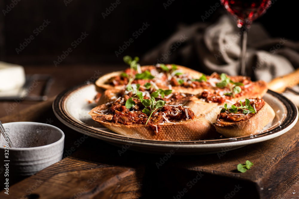 Italian bruschetta with olive paste, parmesan cheese and fresh oregano leaves. Rustick, wooden background.