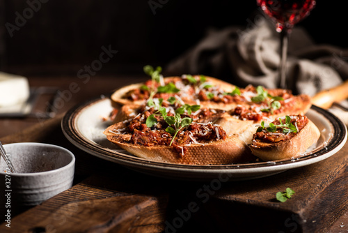 Italian bruschetta with olive paste  parmesan cheese and fresh oregano leaves. Rustick  wooden background.
