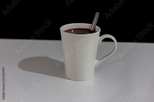 Coffee in a white cup on the table and dark background