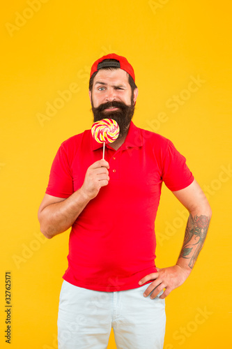 Funny man licking lollipop. Bearded man with lollipop. candy shop assistant. sweet and confectionary. Lollipop fun. Lick it. express positive emotions. sweet tooth happiness