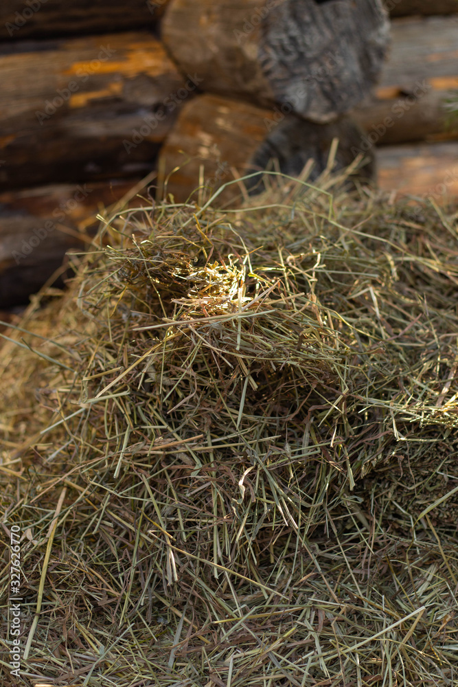 a haystack next to a wooden, log building