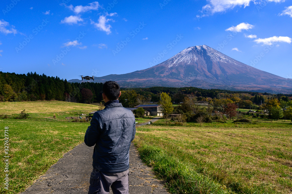 Tourists are controlling drones to fly with a backdrop in Fujisan.