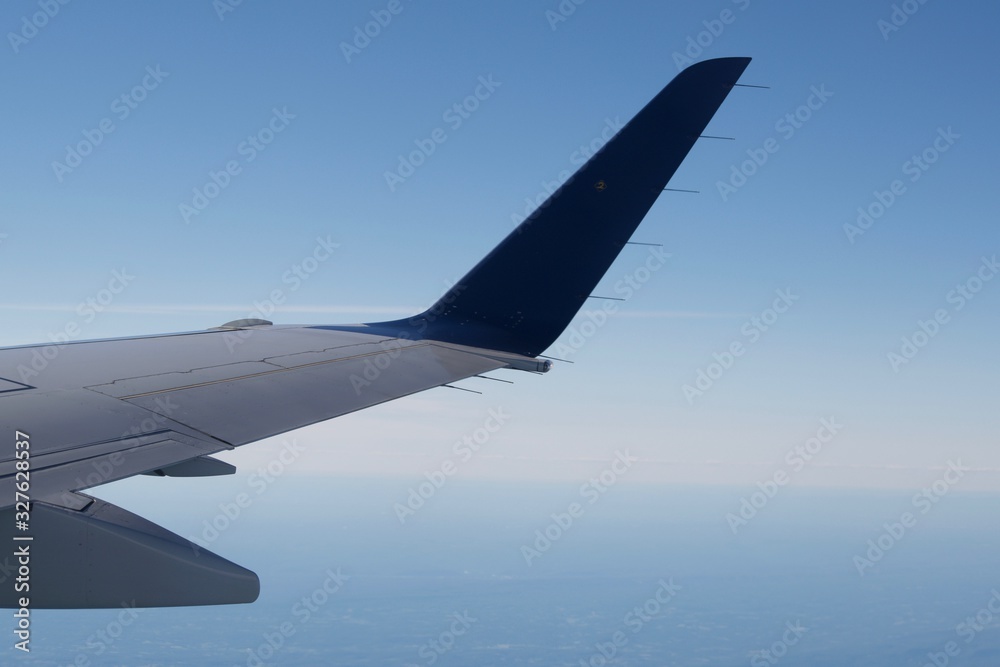 Obraz premium A wing and a prayer above the clouds on plane