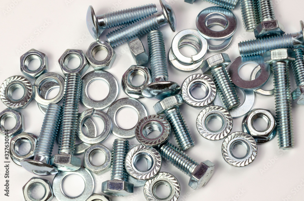 bolts and nuts in a heap on a white background