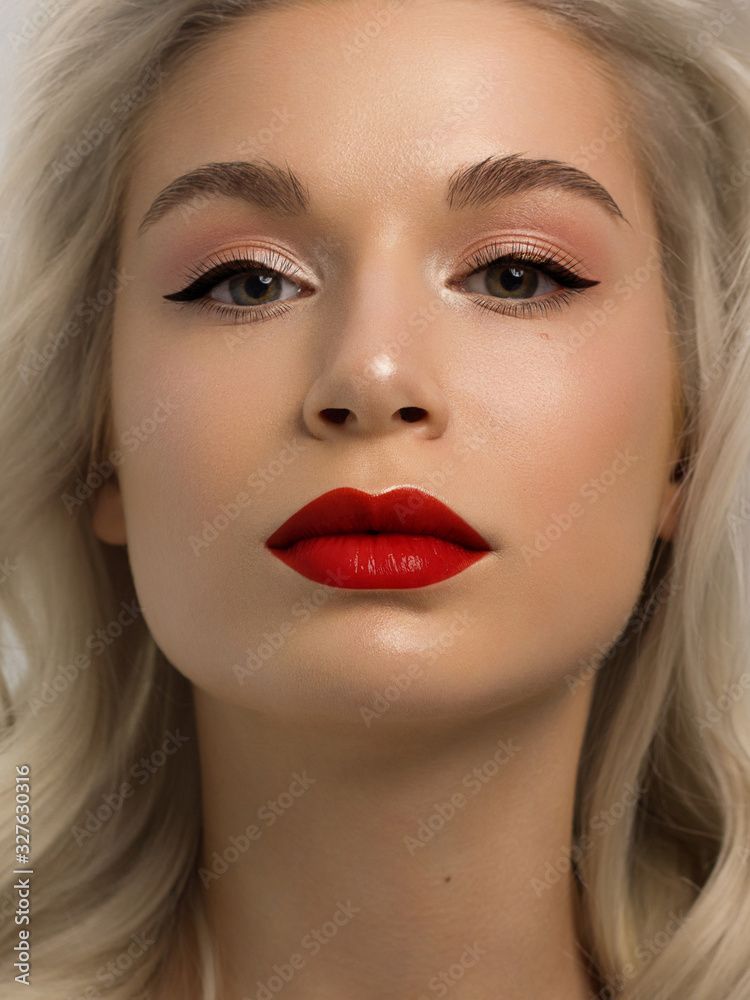 Closeup portrait of a woman with developing straight hair. Sweet tender young girl blonde. Red lipstick, transparent clean skin. Skin care natural cosmetics in the spa salon or cosmetology. Closeup portrait of a woman with developing straight hair. Sweet tender young girl blonde. Red lipstick, transparent clean skin. Skin care natural cosmetics in the spa salon or cosmetology.