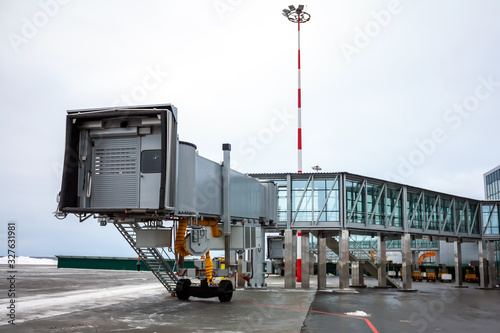 Empty passenger air bridge at the winter airport apron photo